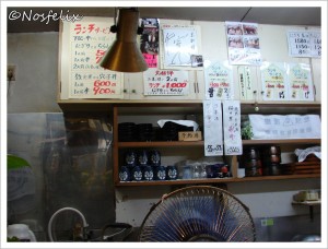 Sushi Restaurants in Tokyo | Kyowa; interior, shelves with cups and menu written in Japanese above